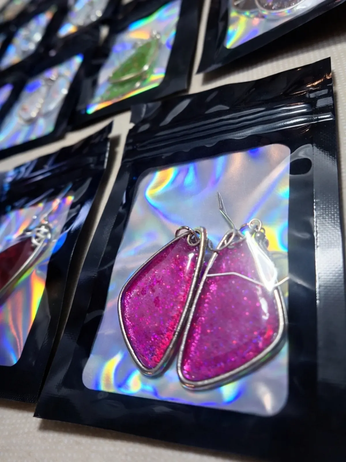 Pink glitter drop earrings in a holographic pouch