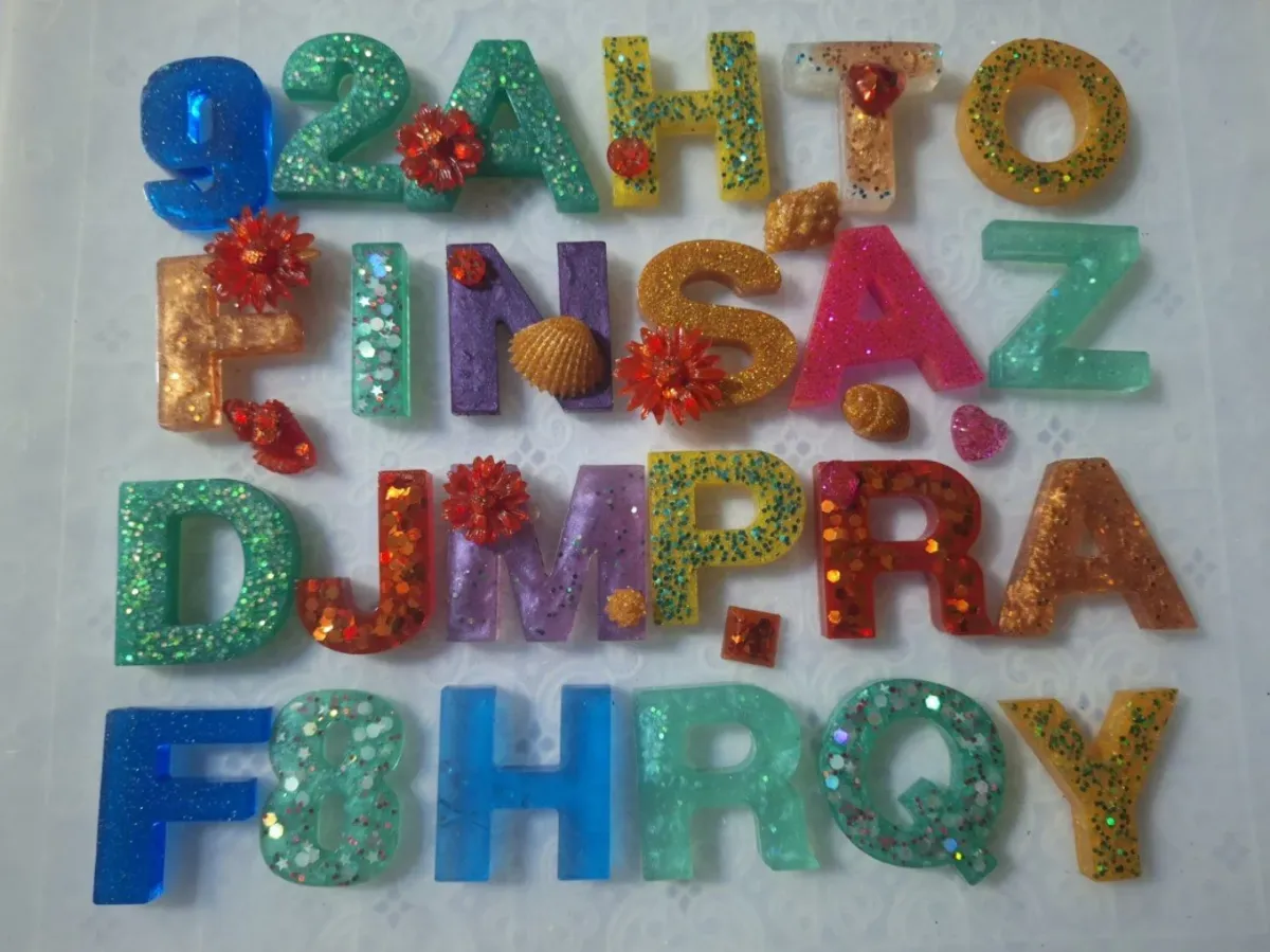 A table of freshly cast glitter resin letters and numbers